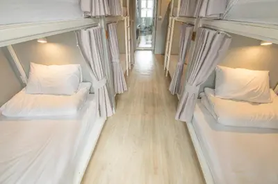 two bunk beds in a room with a wooden floor at Ekanake hostel in Bangkok