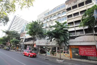 a red car parked in front of a building at Diamond Residence Silom in Bangkok
