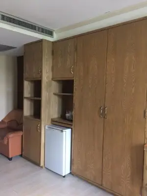 a kitchen with wooden cabinets and a refrigerator at Bourbon St. Boutique Hotel in Bangkok