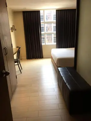 a hotel room with a bed and a window at Bourbon St. Boutique Hotel in Bangkok