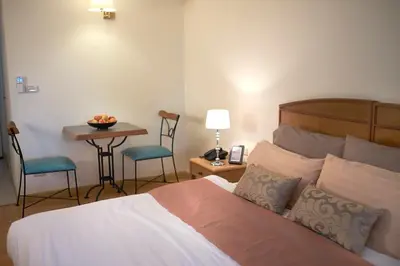 a bedroom with a bed and a table and chairs at Ravipha Residences in Bangkok