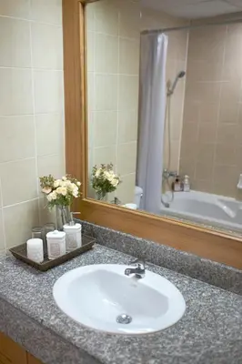 a bathroom counter with a sink and a mirror at Ravipha Residences in Bangkok