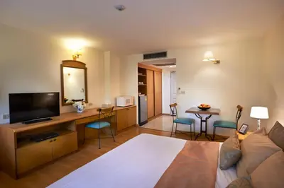 a living room with a couch and a table with chairs at Ravipha Residences in Bangkok