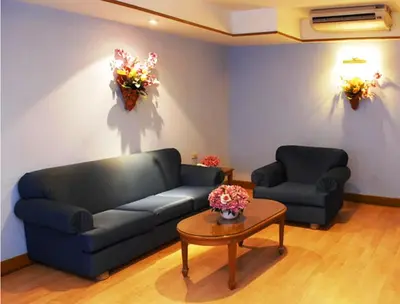 a living room with a couch and a table with flowers at Silom Village Inn in Bangkok