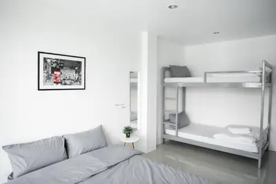 a white bedroom with a bed and bunk beds at Studio 41 Salaya-Sai4 in Nakhon Pathom