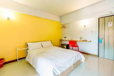 a bedroom with a bed and a yellow wall at Living Naraa Place in Bangkok