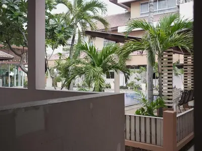 a balcony with palm trees in front of a building at Teja Hotel in Bangkok
