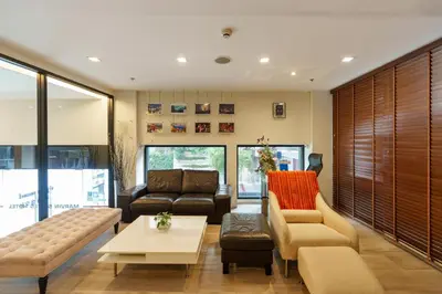 a living room with a couch and a table at Marvin Suites Hotel in Bangkok