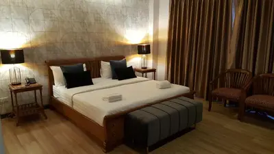 a bedroom with a bed with two chairs and two lamps at W 21 Hotel Bangkok in Bangkok