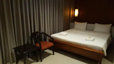 a bedroom with a bed and a chair and a table at W 21 Hotel Bangkok in Bangkok