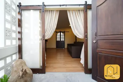 an open door into a living room with a couch at Na Vayla PaPlern in Bangkok