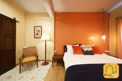 a bedroom with a bed with an orange wall at Na Vayla PaPlern in Bangkok