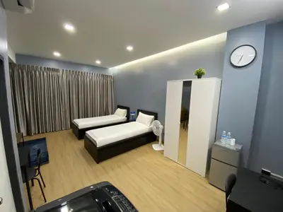 a room with a bed and a mirror and a clock at Bangyai Inn-private room in Nonthaburi
