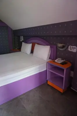 a purple bed in a room with a phone on a table at 58 Ville Resort in Bangkok