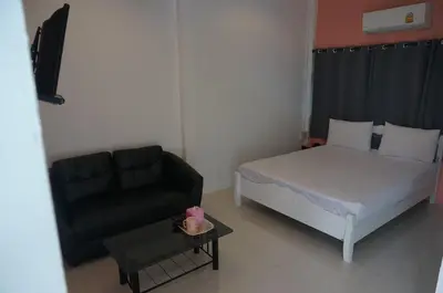a small bedroom with a bed and a couch at 58 Ville Resort in Bangkok