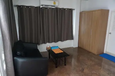 a living room with a black chair and a table at 58 Ville Resort in Bangkok