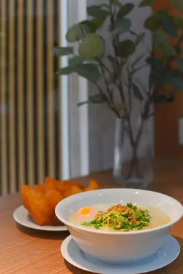 a bowl of soup on a table with a plate of food at Grand Watergate Hotel in Bangkok