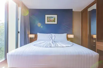 a bedroom with a white bed with a blue wall at Amp Am House Bangkok Hotel in Bangkok