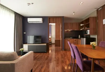 a living room with a table and purple chairs at Amp Am House Bangkok Hotel in Bangkok