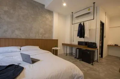 a bedroom with a bed with a laptop on it at Lost Inn BKK in Bangkok