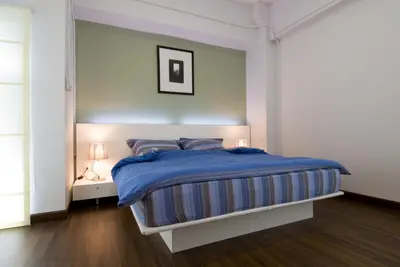 a bedroom with a bed with a blue blanket at T Series Place Serviced Apartment in Bangkok