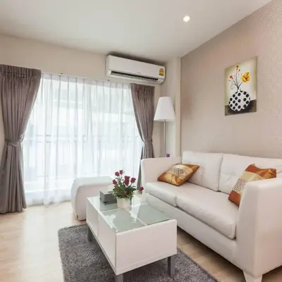 a living room with a white couch and a table at The Cube Residence Government Complex Laksi in Lak Si