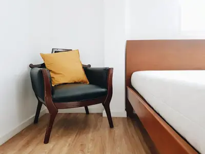 a chair with a yellow pillow sitting next to a bed at LITA Bangkok in Bangkok