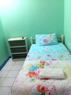 a bedroom with a bed with a floral bedspread at NAT 2 Guest House in Bangkok