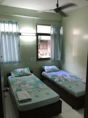 two beds in a room with a window at NAT 2 Guest House in Bangkok
