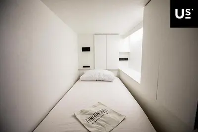 a small room with a bed with a cocacola bag on it at the CAPSULE by UnionSPACE in Bangkok