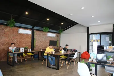 a group of people sitting at tables in a restaurant at the CAPSULE by UnionSPACE in Bangkok
