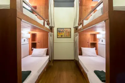 two bunk beds in a room with wood paneling at Suneta Hostel Khaosan in Bangkok