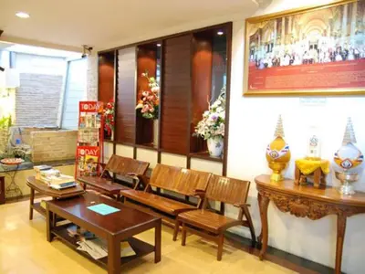 a room with wooden chairs and a table and a table and chairs at Rambuttri House in Bangkok