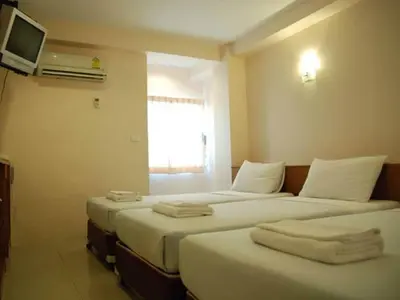 a hotel room with three beds with towels on them at Rambuttri House in Bangkok