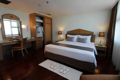 a hotel room with a large bed and a desk at Grand Tower Inn Rama 6 in Bangkok