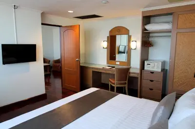 a hotel room with a bed and a desk in it at Grand Tower Inn Rama 6 in Bangkok