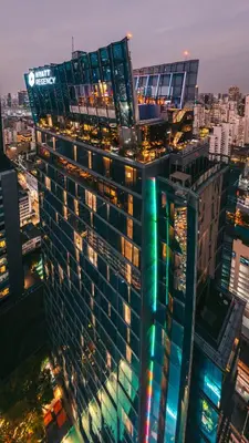 a tall building with green lights on top of it at Hyatt Regency Bangkok Sukhumvit in Bangkok
