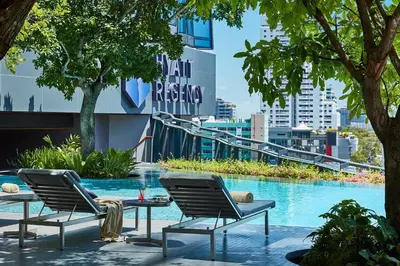 two chairs and a table next to a swimming pool at Hyatt Regency Bangkok Sukhumvit in Bangkok