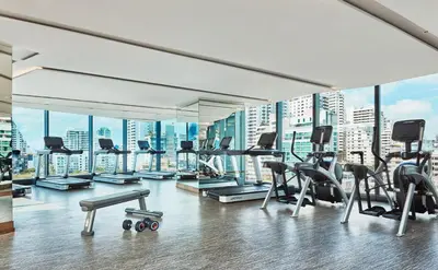 a gym with a view of a city skyline at Hyatt Regency Bangkok Sukhumvit in Bangkok