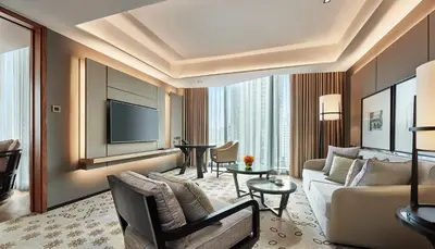 a living room with a couch and a tv at Hyatt Regency Bangkok Sukhumvit in Bangkok