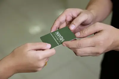 two hands holding a piece of green card at Nantra Sukhumvit 39 in Bangkok