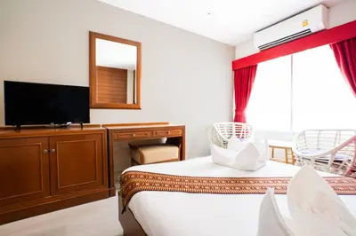 a hotel room with two beds and a flat screen tv at Baan Sukhumvit Soi 18 in Bangkok
