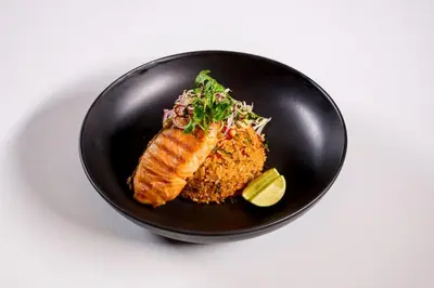 a black plate of food with fish and rice at TK Palace Hotel & Convention Bangkok in Bangkok