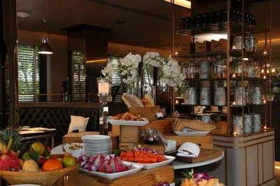 a buffet with fruits and vegetables in a restaurant at Riva Surya Bangkok in Bangkok