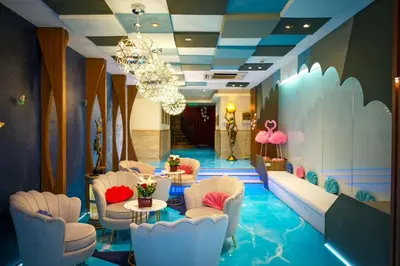 a lobby with chairs and tables and a chandelier at Hotel Mermaid Bangkok in Bangkok