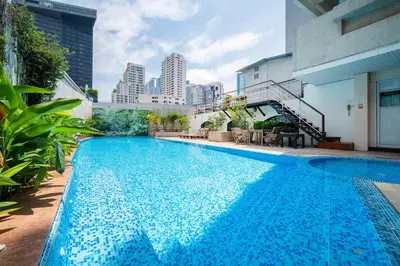 a large blue swimming pool in the middle of a building at Hotel Mermaid Bangkok in Bangkok