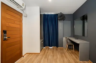 a room with a desk and a blue curtain at 19A Bangkok in Bangkok