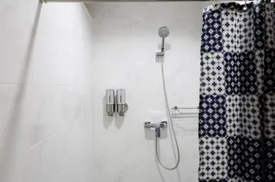a shower with a shower head and a shower curtain at 19A Bangkok in Bangkok