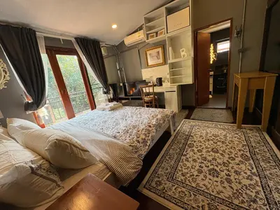 a bedroom with a bed and a large window at Narra House Sukhumvit58 in Bangkok