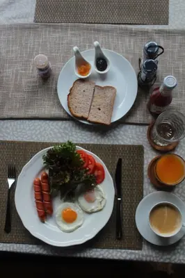 two plates of food with eggs and bread and tomatoes at Narra House Sukhumvit58 in Bangkok